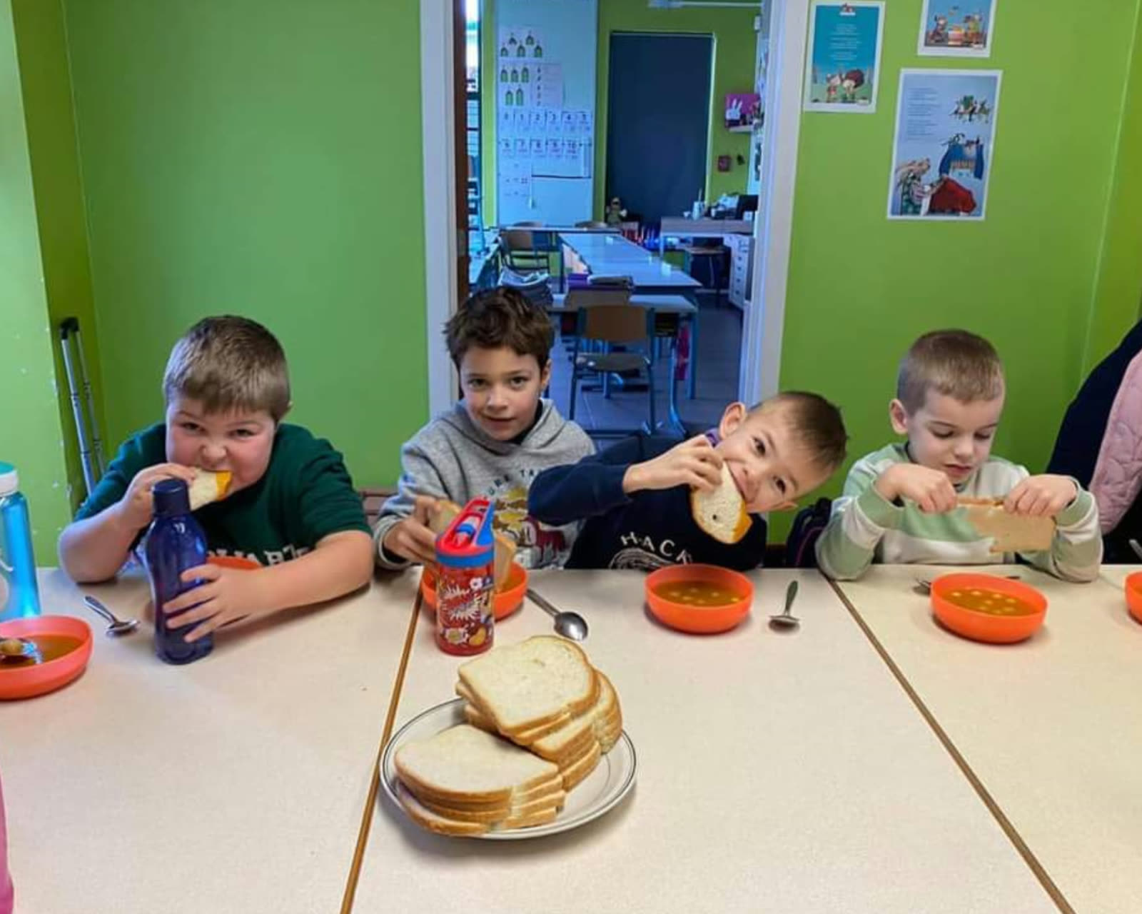 Kinderen aan tafel in de refter van de school