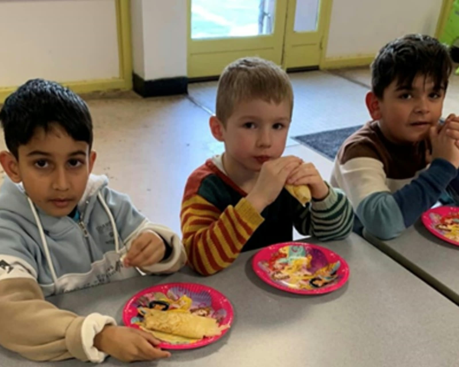 Lachende kinderen tijdens het middagmaal